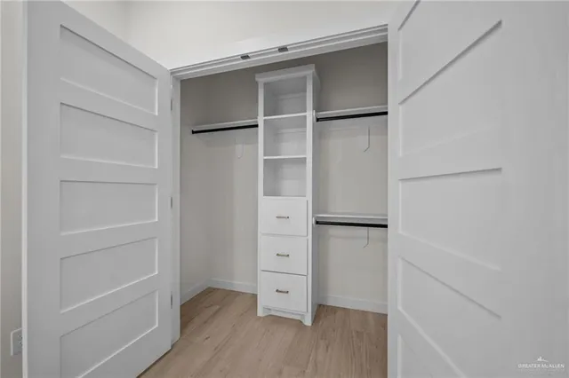 a view of walk in closet with empty racks