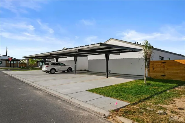 a car parked in front of a house next to a yard