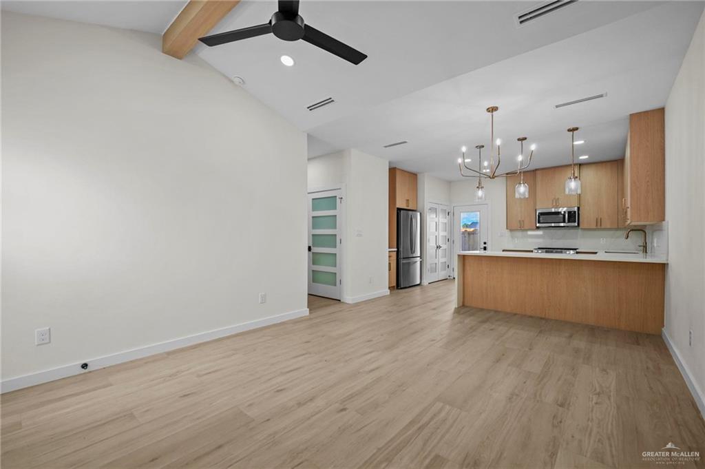 2709 Mockingbird Road, Unit 4 Weslaco, TX 78596 - Photo 3 of 20 a large kitchen with a wooden floor and stainless steel appliances