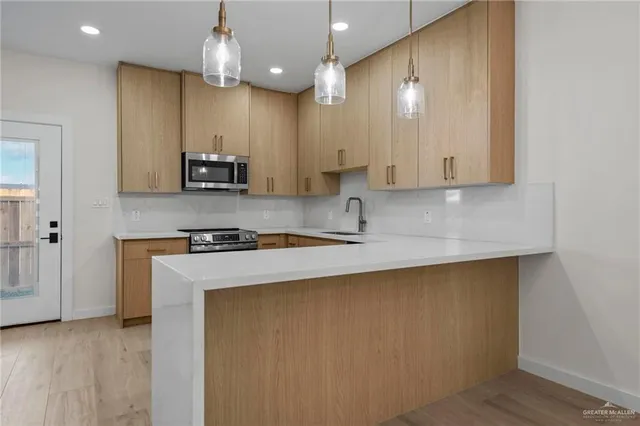 a kitchen with stainless steel appliances granite countertop a stove a sink and a microwave