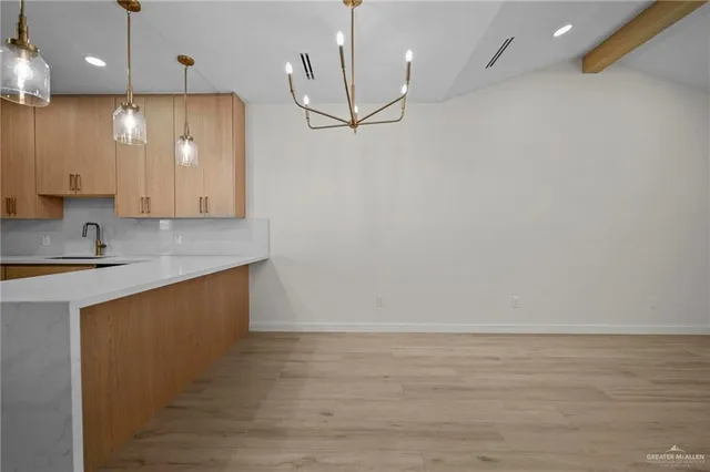 a view of a kitchen with a sink and refrigerator