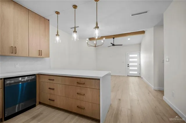 a kitchen with a white cabinets and wooden floor