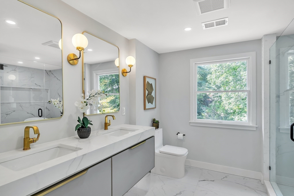 95 Country Club Road Dedham, MA 02026 - Photo 12 of 21 a bathroom with a granite countertop sink a toilet and a window