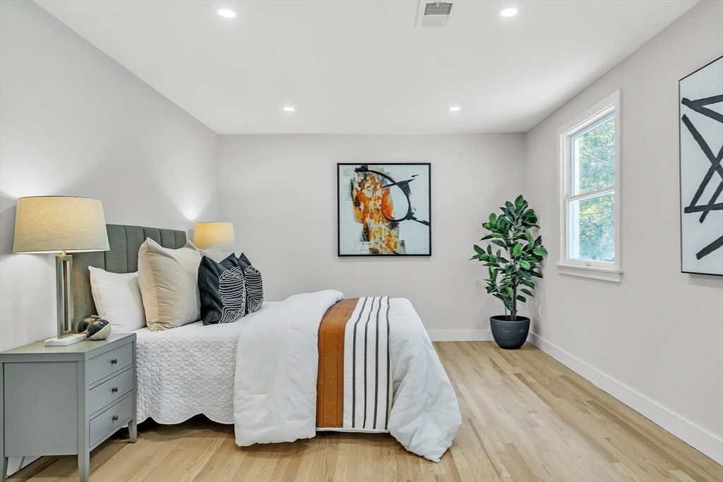 95 Country Club Road Dedham, MA 02026 - Photo 15 of 21 a spacious bedroom with a bed and a painting on the wall