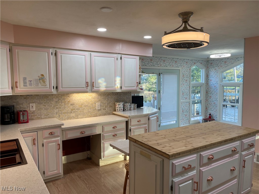 170 Burns Road Elyria, OH 44035 - Photo 18 of 32 Kitchen featuring a kitchen island, pendant lighting, decorative backsplash, white cabinets, and light wood-type flooring