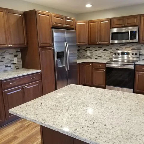 a kitchen with stainless steel appliances wooden cabinets a refrigerator and a stove
