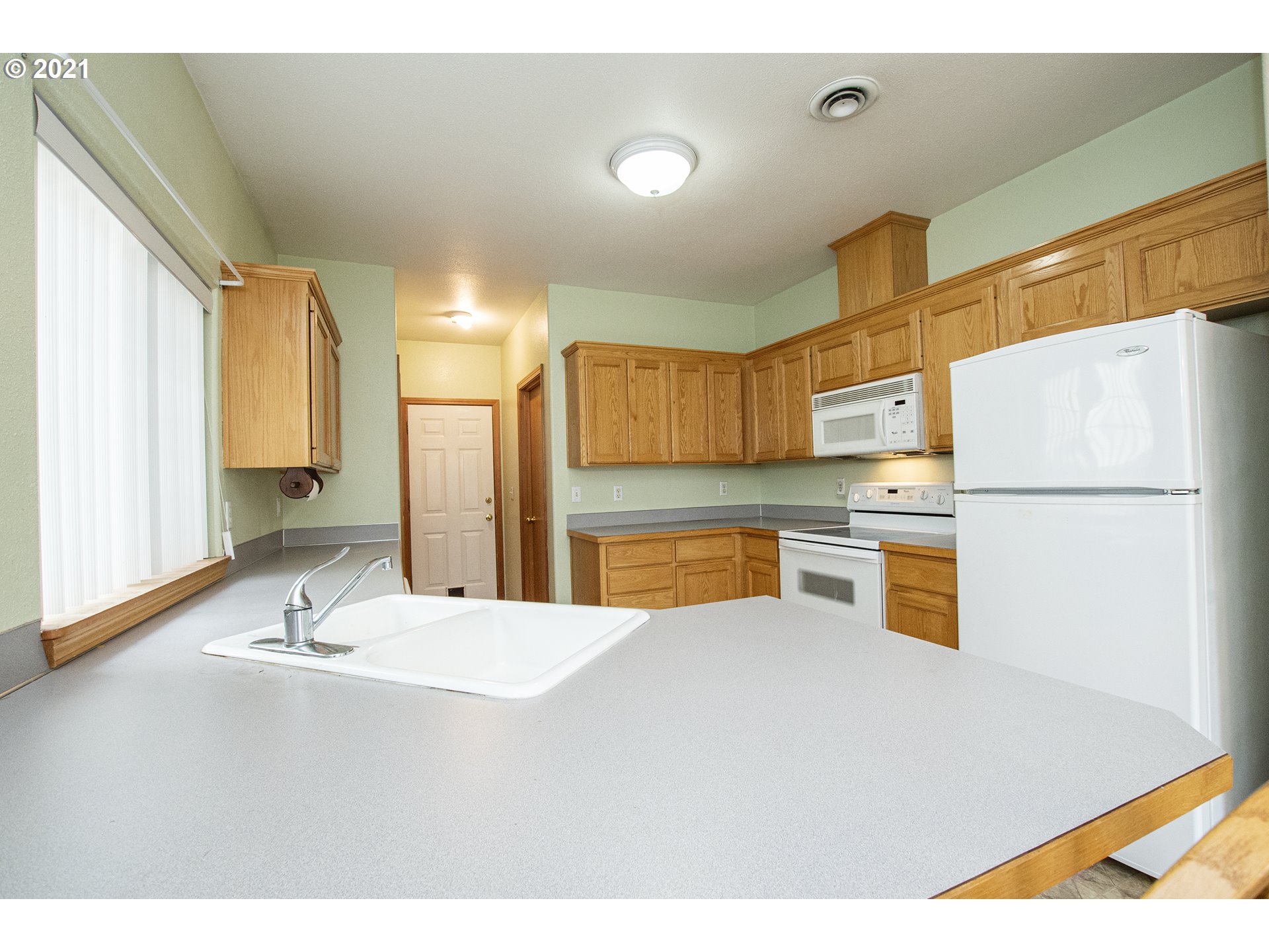 4142 South E Street Springfield, OR 97478 - Photo 8 of 26 a kitchen with stainless steel appliances a sink and a refrigerator