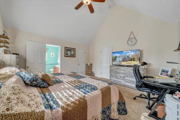 a bedroom with a bed and a view of kitchen