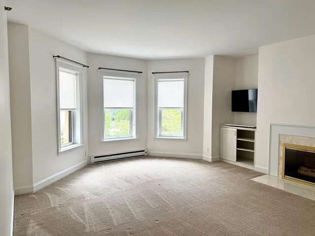 a view of empty room with a fireplace and windows