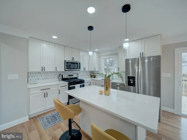 a kitchen with stainless steel appliances granite countertop a sink refrigerator and cabinets