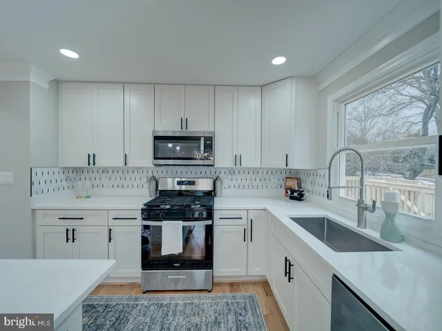 a kitchen with sink a microwave and cabinets