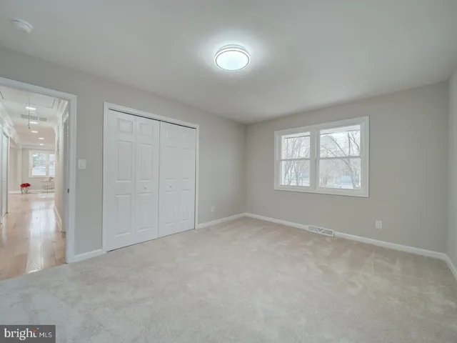 an empty room with windows and closet