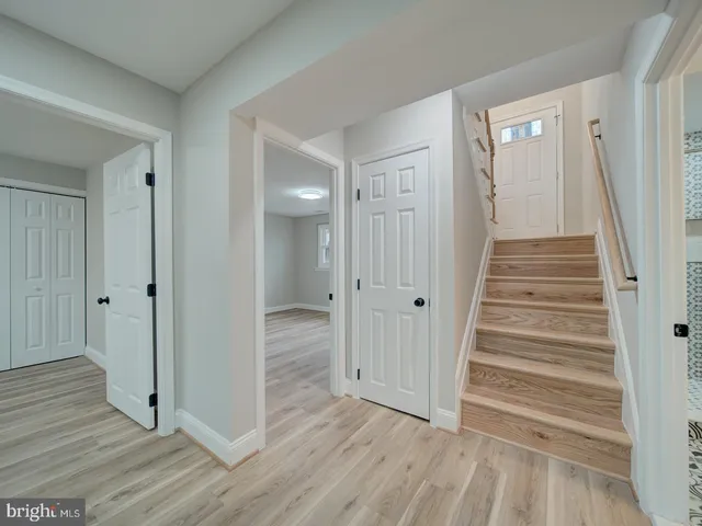 a view of a hallway with wooden floor and staircase