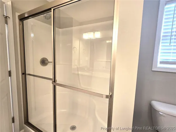a bathroom with a granite countertop sink mirror and shower