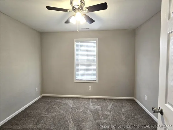 an empty room with chandelier fan