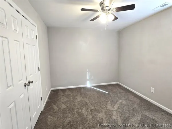 an empty room with a window and a fan