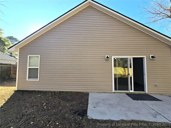 a view of a house with backyard and tree