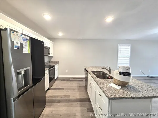 a kitchen with stainless steel appliances granite countertop a sink and a refrigerator