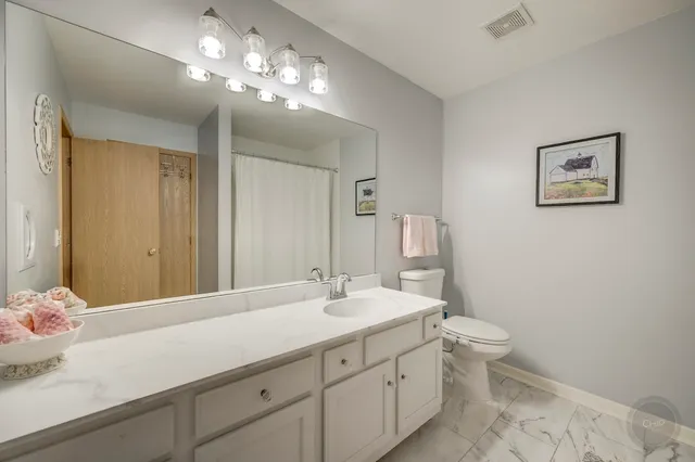 a bathroom with a toilet a sink and a mirror