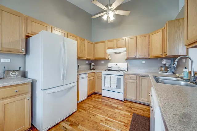 a kitchen with a refrigerator a sink stainless steel appliances and cabinets