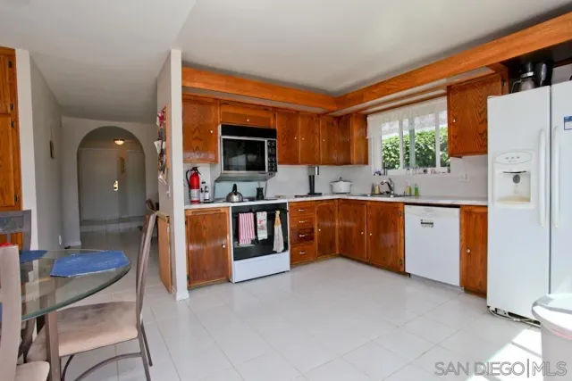 a living room with stainless steel appliances furniture a fireplace and a flat screen tv