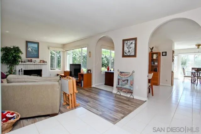 a living room with furniture a fireplace and a large window