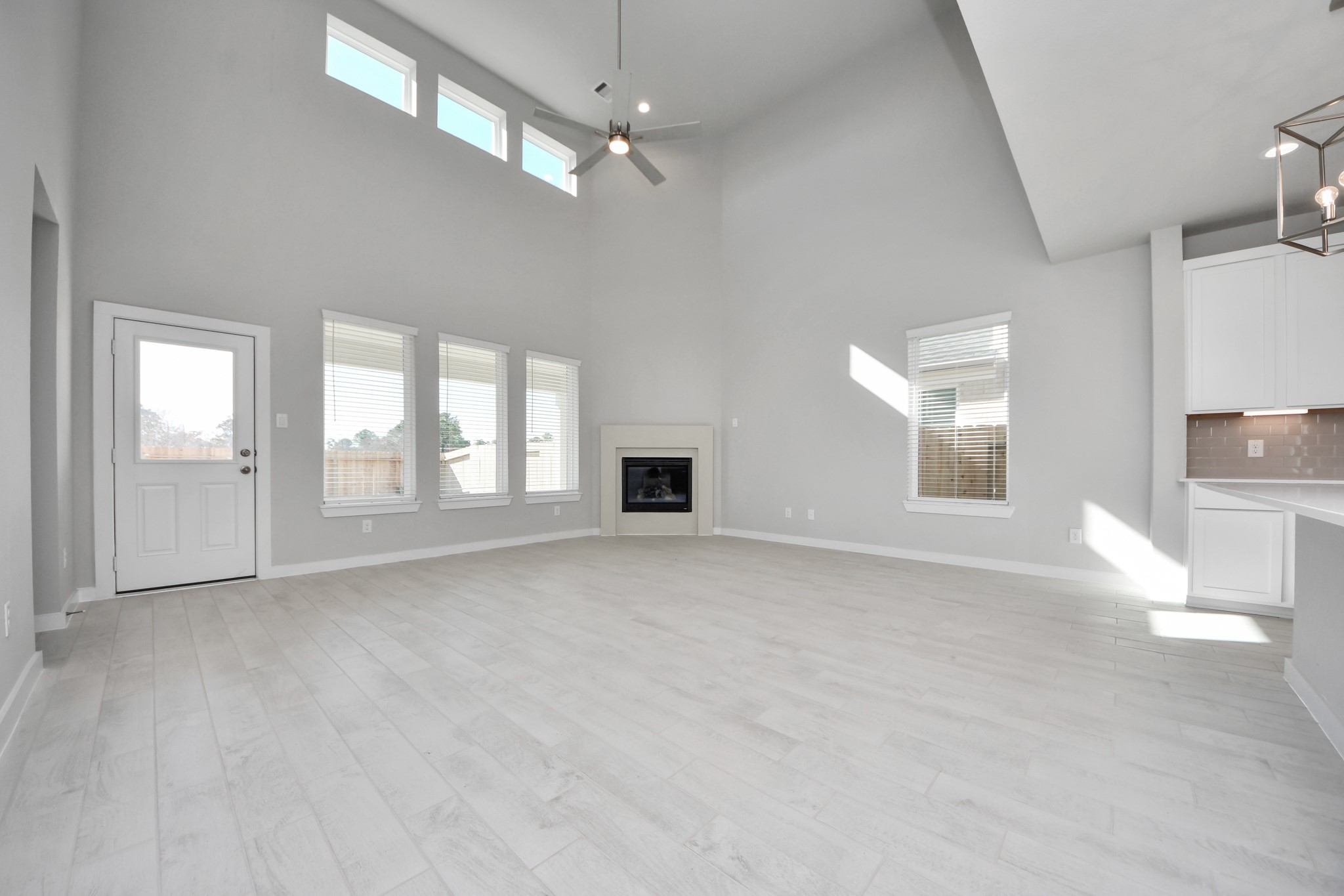 2926 Bury Park Dr Spring Spring, TX 77373 - Photo 17 of 38 Welcome family and guests to your charming living room! With its high ceilings, recessed lighting, ceiling fan, custom paint, beautiful flooring, and large windows that let in abundant natural light, this room is perfect for gatherings. Sample photo of completed home with similar floor plan. Actual colors and selections may vary.