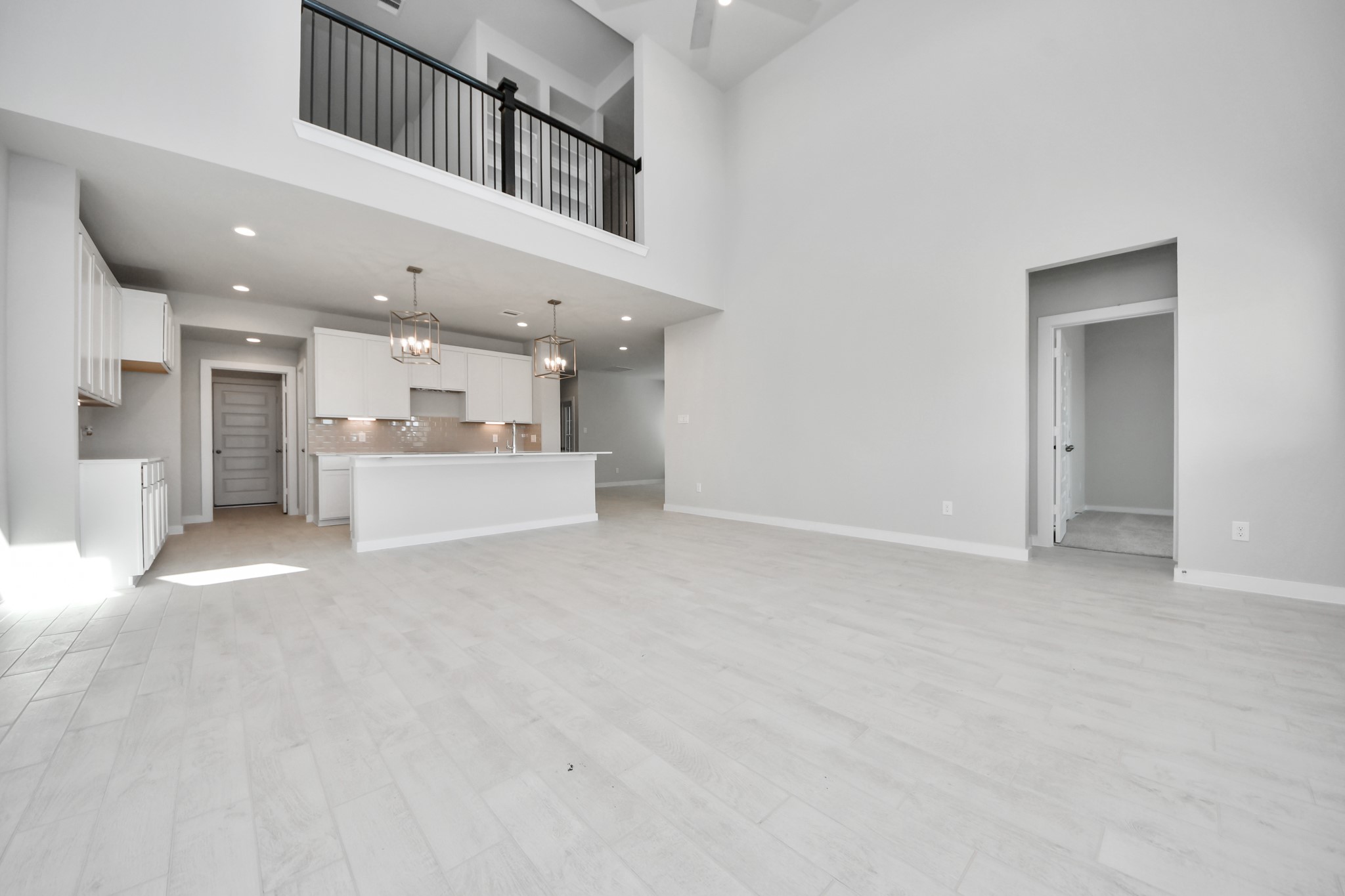 2926 Bury Park Dr Spring Spring, TX 77373 - Photo 18 of 38 Gather the family and guests together in your lovely living room! Featuring soaring high ceilings, recessed lighting, ceiling fan, custom paint, gorgeous floors, and large windows that provide plenty of natural lighting throughout the day. Sample photo of completed home with similar floor plan. Actual colors and selections may vary.