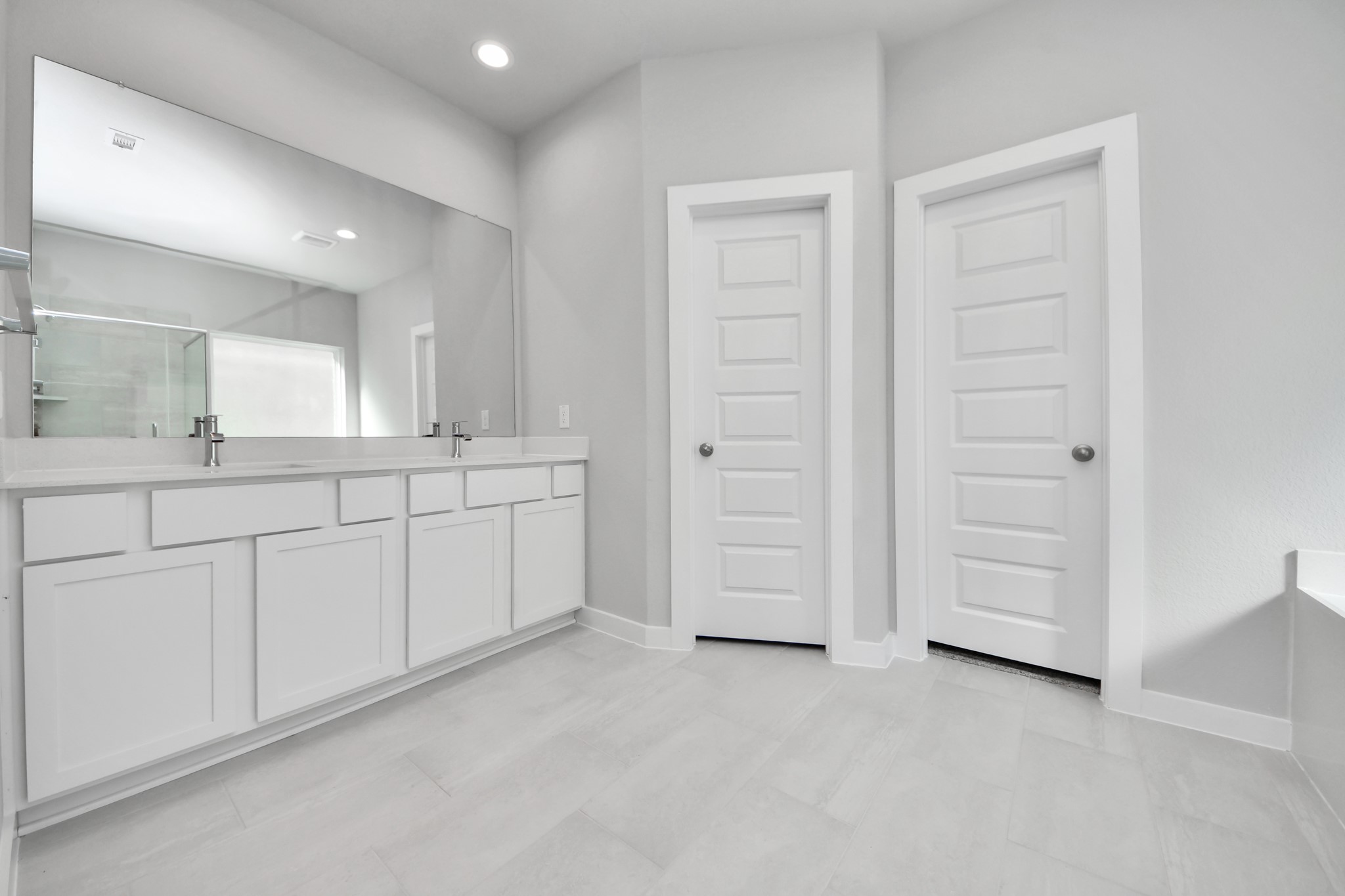 2926 Bury Park Dr Spring Spring, TX 77373 - Photo 23 of 38 Escape to a spa-like oasis in this primary bathroom. Enjoy a walk-in shower with tile surround, a separate garden tub with custom detailing, and an elegant vanity featuring light countertops, modern hardware, and beautiful vanity lights. Experience luxury and relaxation in every detail. Sample photo of completed home with similar floor plan. Actual colors and selections may vary.