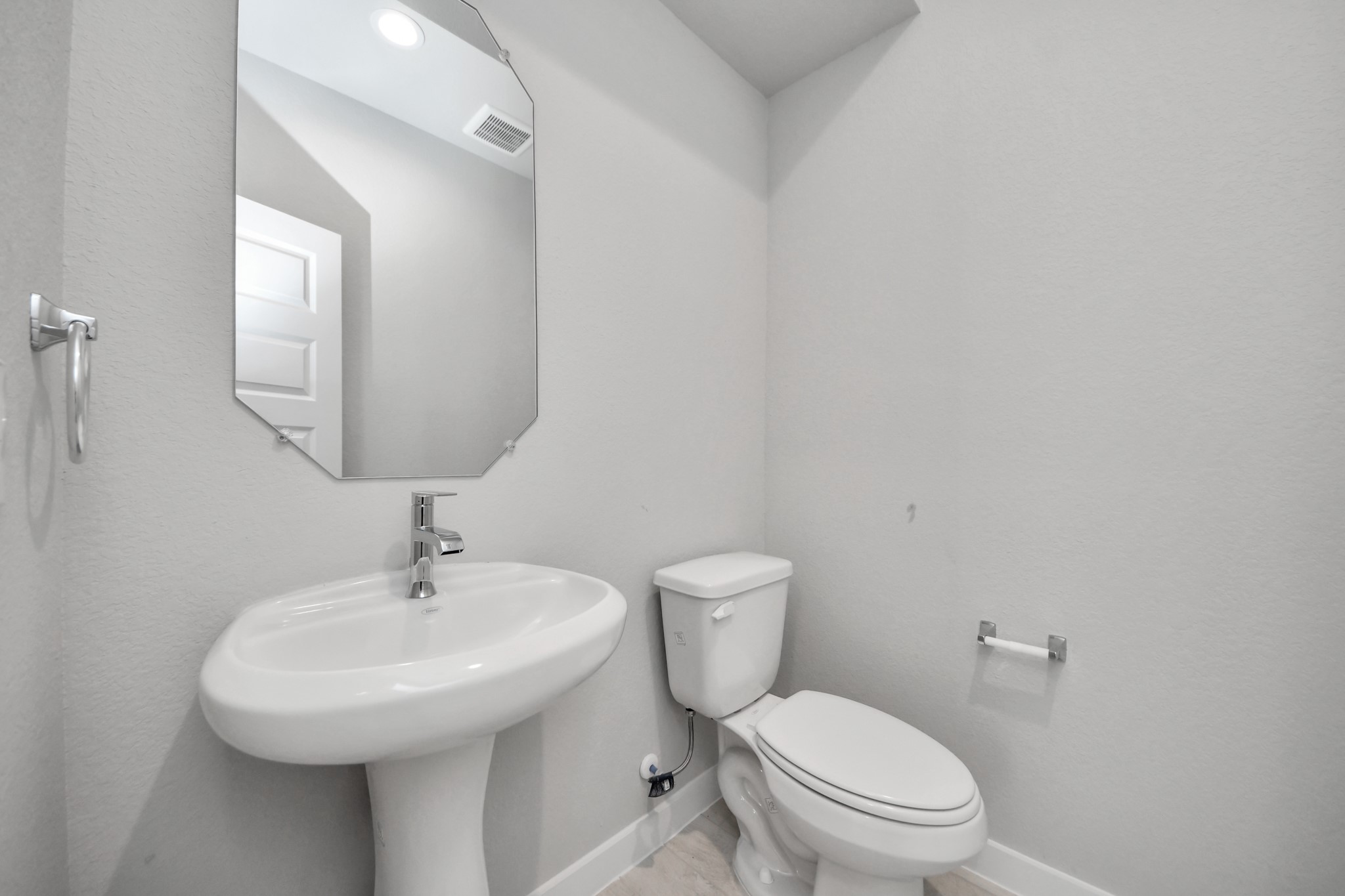 2926 Bury Park Dr Spring Spring, TX 77373 - Photo 6 of 38 This half bathroom features a stylish pedestal sink, modern hardware, and bright recessed lighting, creating a sleek and inviting space. Sample photo of completed home with similar floor plan. Actual colors and selections may vary.