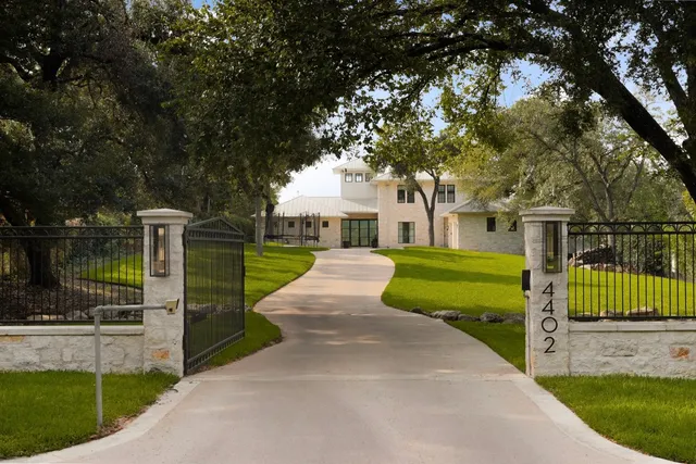 a view of a house with a big yard and large tree
