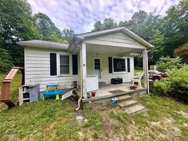 a view of house with backyard and outdoor seating