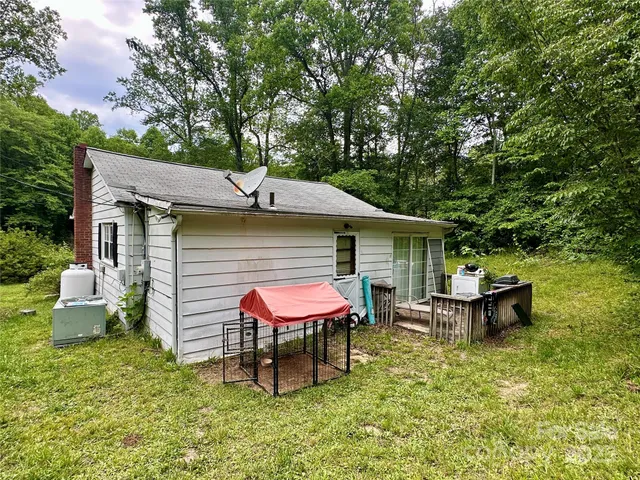 a view of a backyard with table and chairs under an umbrella
