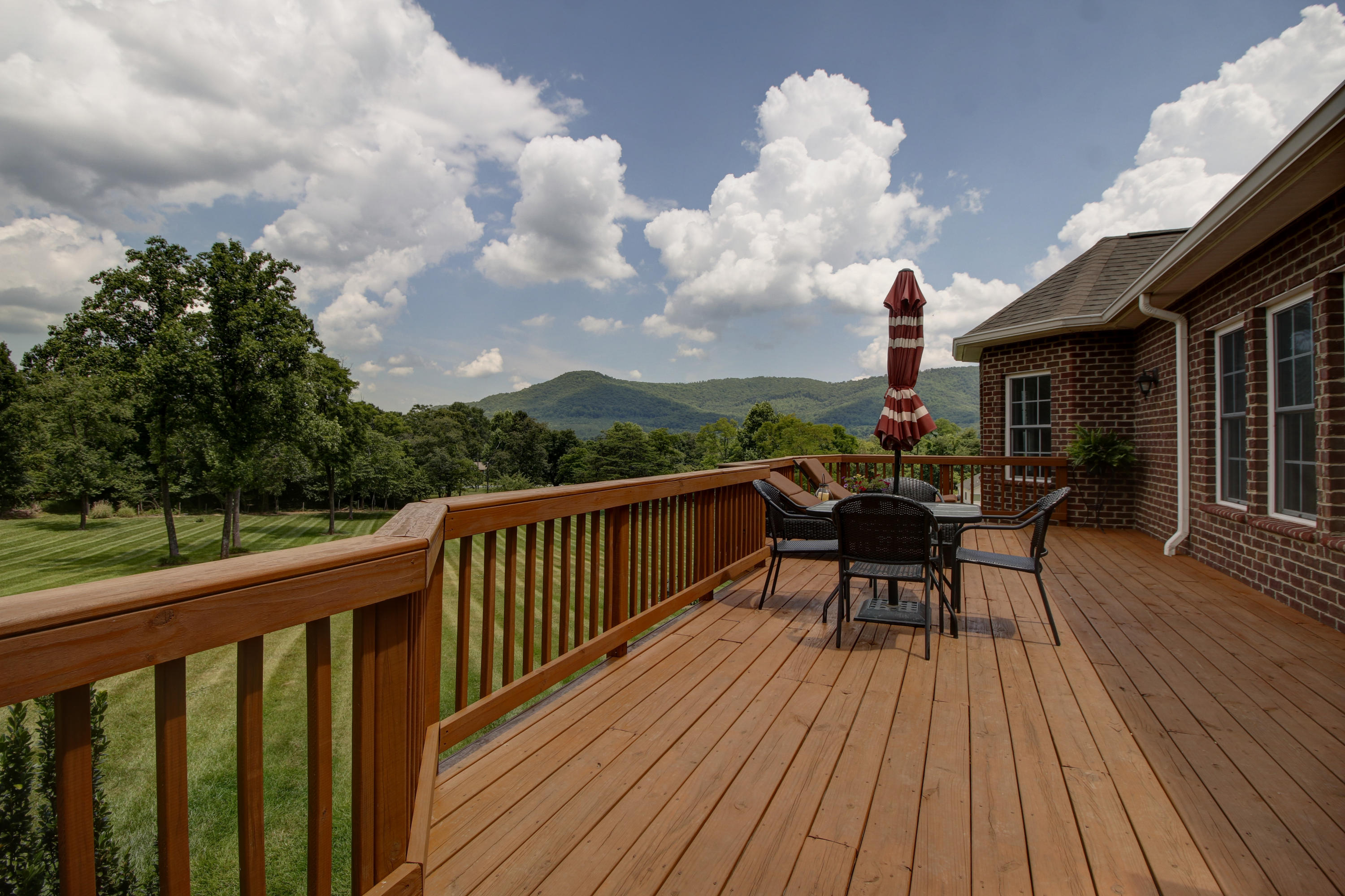 412 Thornblade Way Blue Ridge, VA 24064 - Photo 40 of 47 a view of a roof deck with table and chairs a barbeque with wooden floor and fence