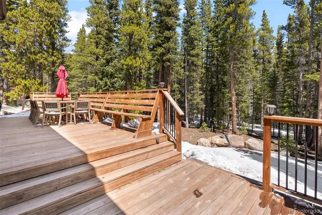 a view of a patio with wooden floor and iron fence