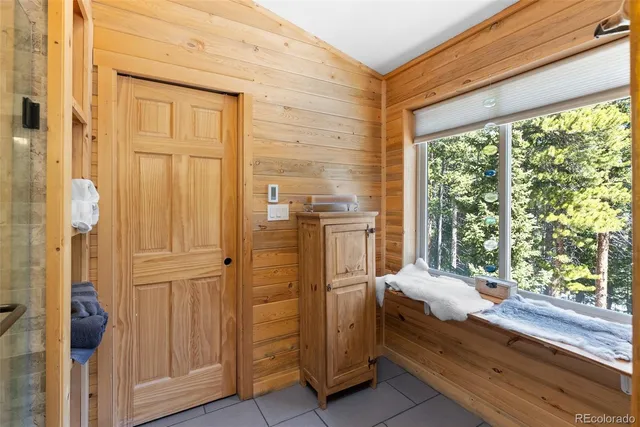 a bedroom with a bed and large windows