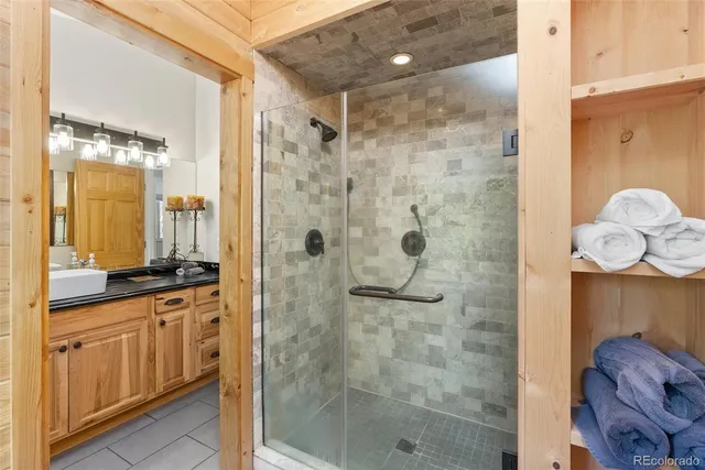 a bathroom with a granite countertop shower a sink and a mirror