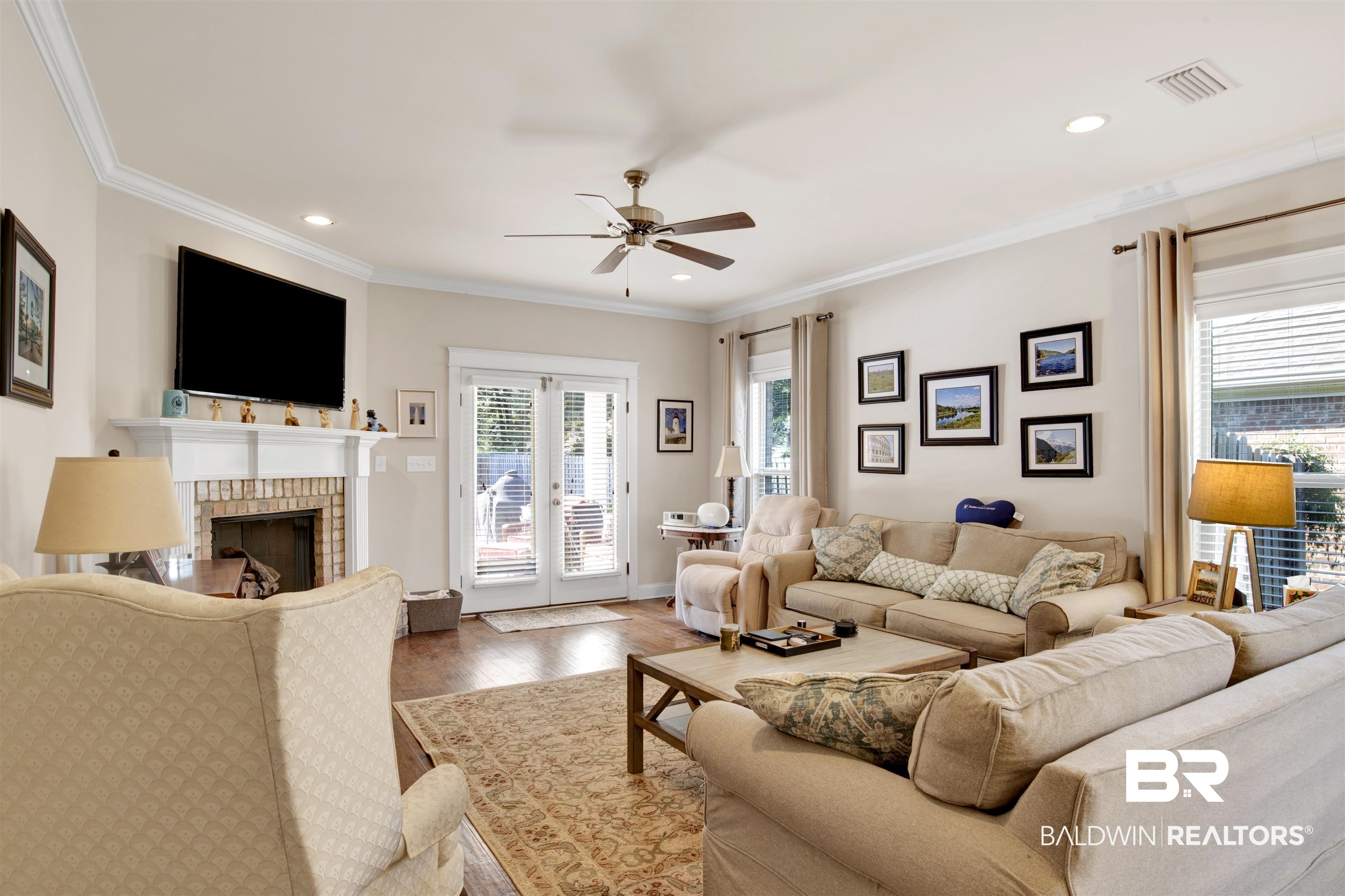 360 Scarlett Avenue Fairhope, AL 36532 - Photo 19 of 34 Living room featuring a brick fireplace, wood-type flooring, ceiling fan, and crown molding
