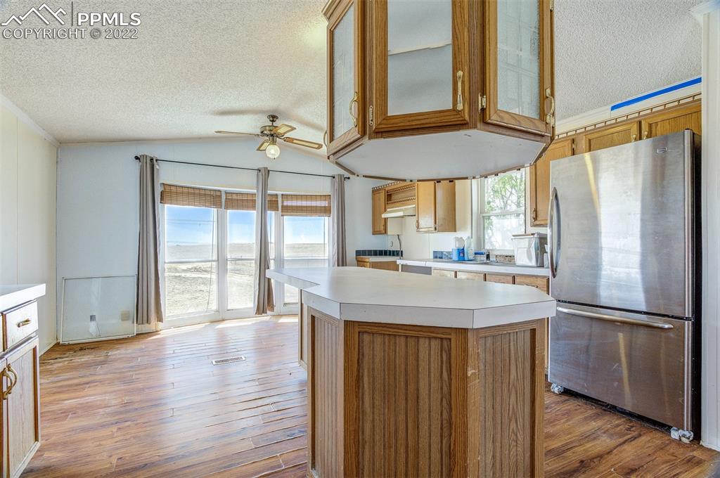 36210 Heavenly View Yoder, CO 80864 - Photo 13 of 42 a kitchen with stainless steel appliances granite countertop a refrigerator a sink and a stove with wooden floor