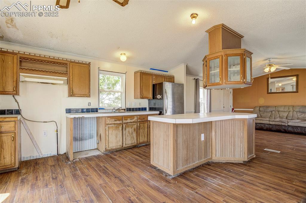 36210 Heavenly View Yoder, CO 80864 - Photo 16 of 42 a kitchen with stainless steel appliances granite countertop a stove a sink dishwasher a refrigerator and white cabinets with wooden floor