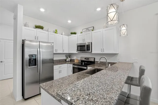 a living room with furniture kitchen view and a flat screen tv