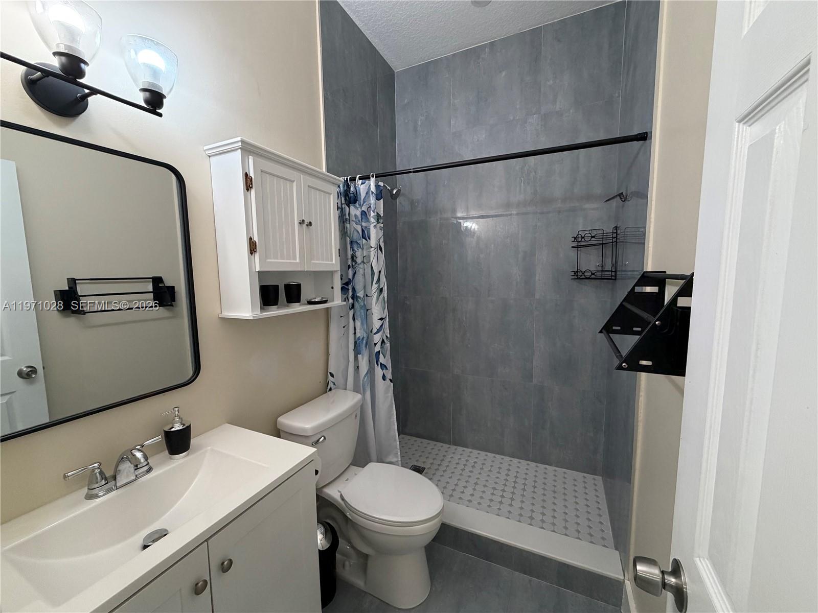 18255 Southwest 145th Avenue, Unit BACK Miami, FL 33177 - Photo 13 of 15 a bathroom with a sink toilet and shower
