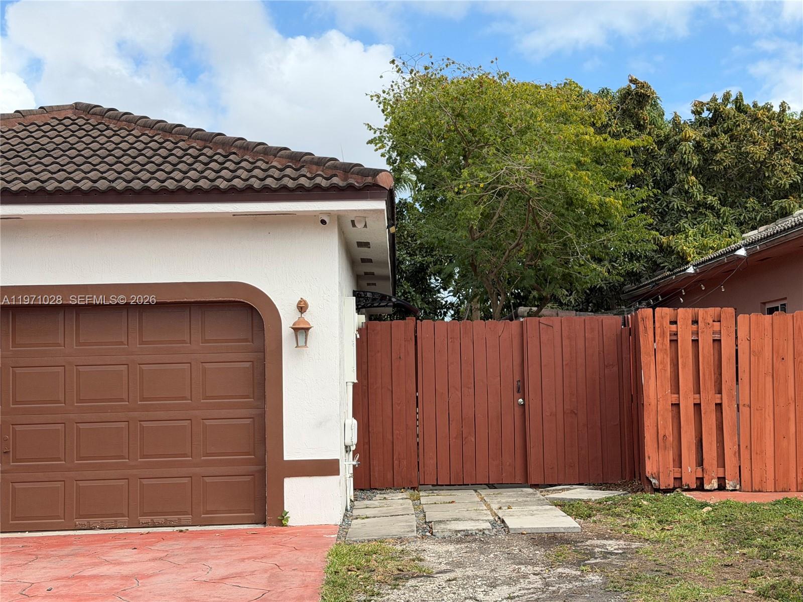 18255 Southwest 145th Avenue, Unit BACK Miami, FL 33177 - Photo 2 of 15 a view of a house with a wooden fence