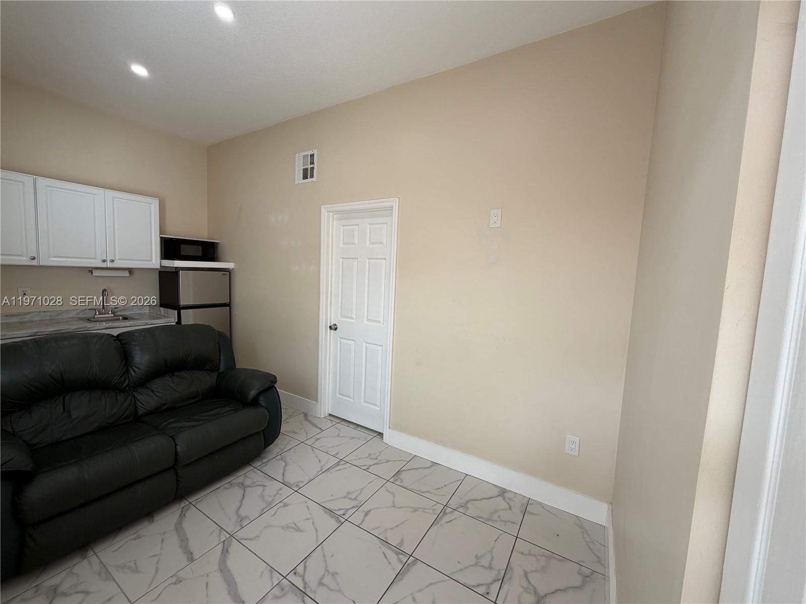 18255 Southwest 145th Avenue, Unit BACK Miami, FL 33177 - Photo 5 of 15 a living room with furniture and a refrigerator