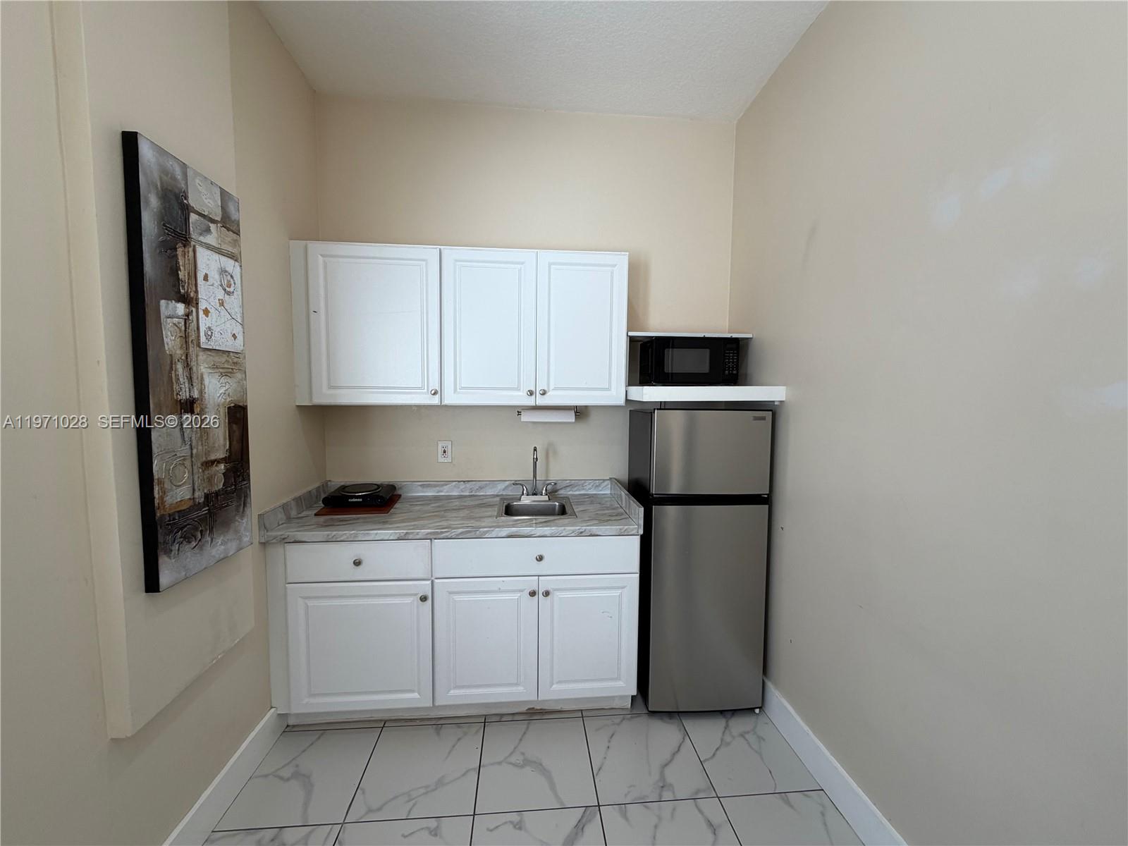 18255 Southwest 145th Avenue, Unit BACK Miami, FL 33177 - Photo 8 of 15 a kitchen with a stove top oven and cabinets