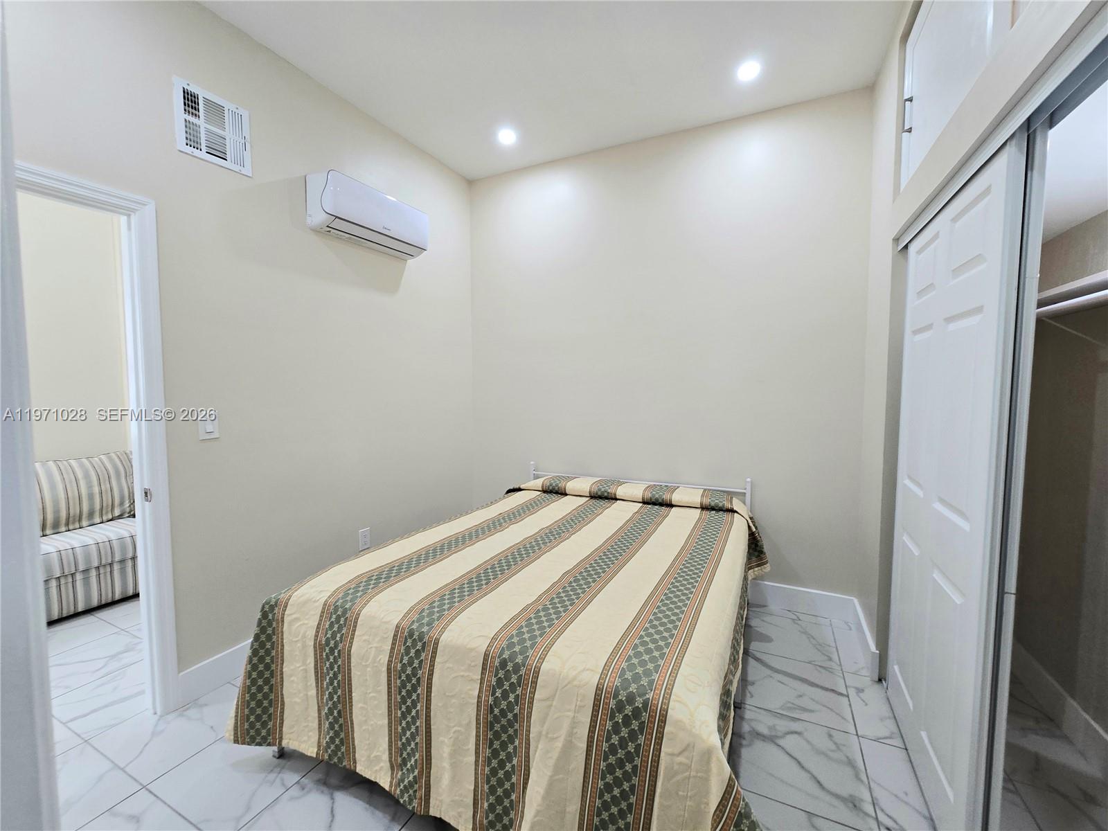 18255 Southwest 145th Avenue, Unit BACK Miami, FL 33177 - Photo 10 of 15 a bedroom with a bed and a walk in closet
