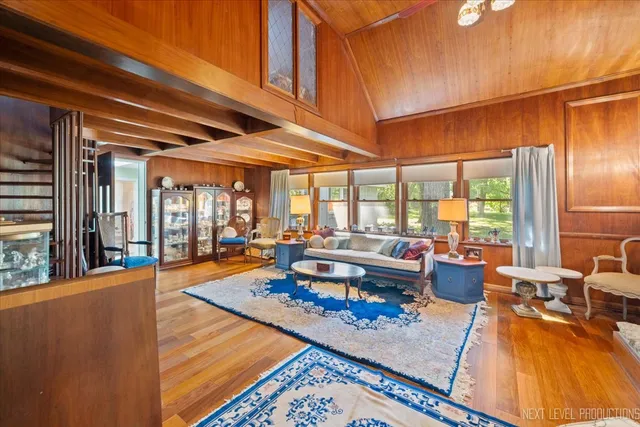 a living room with furniture a rug and a dining table