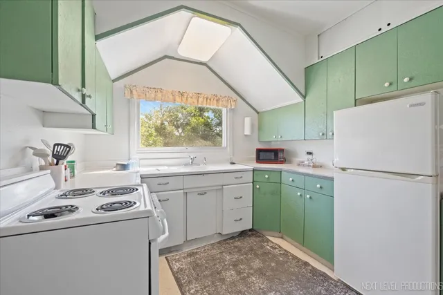a kitchen with a refrigerator sink and cabinets