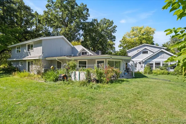 a front view of house with yard and trees in the background