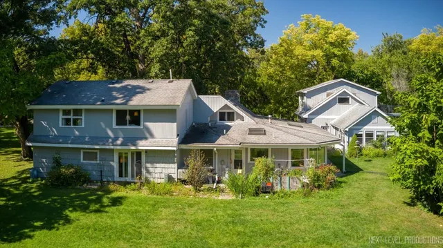 a front view of a house with a garden and trees